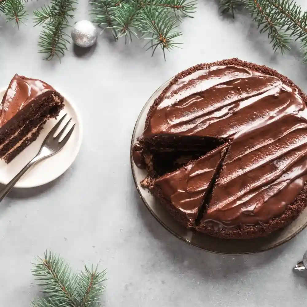 A rich and moist chocolate cake, frosted with creamy chocolate ganache, and garnished with chocolate shavings.