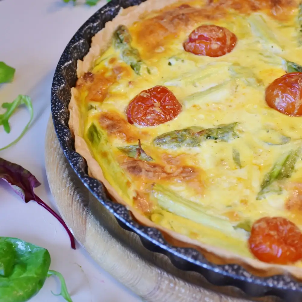 A slice of tortilla quiche bake with layers of eggs, cheese, and vegetables, served on a plate.