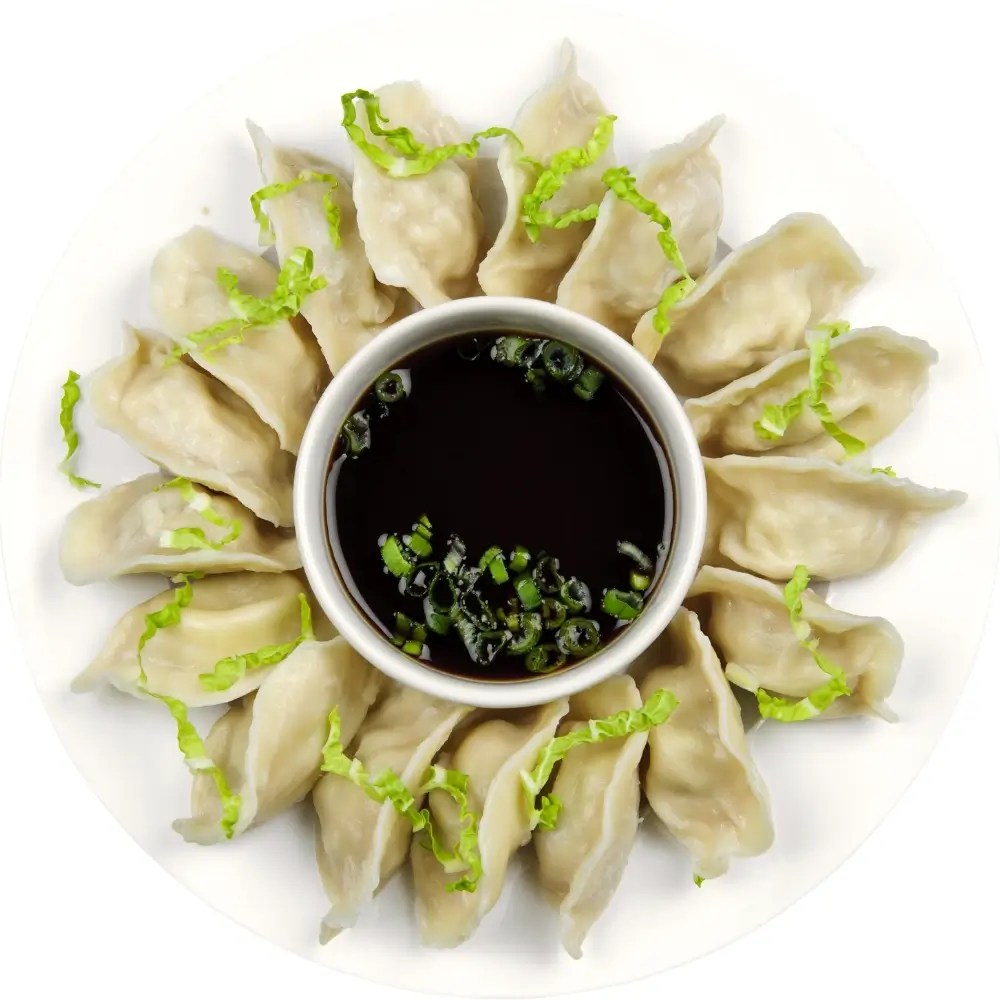A bottle of homemade soy sauce, rich in color and texture, next to a small dish for serving.
